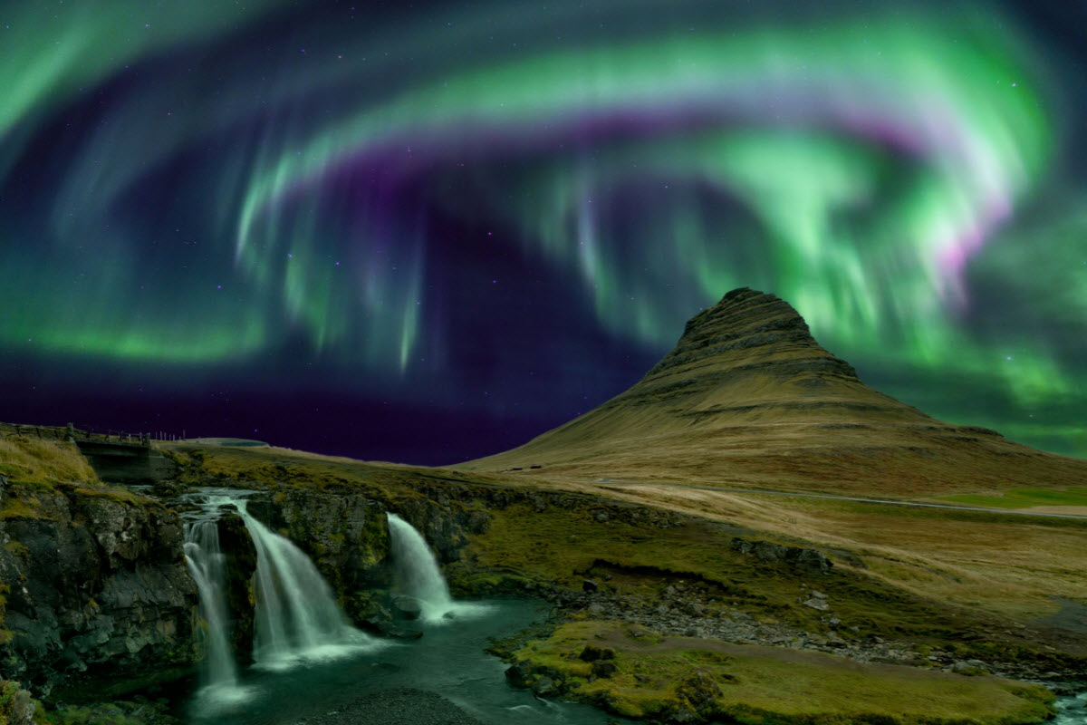 The Northern Lights dancing around above Kirkjufell Mountain