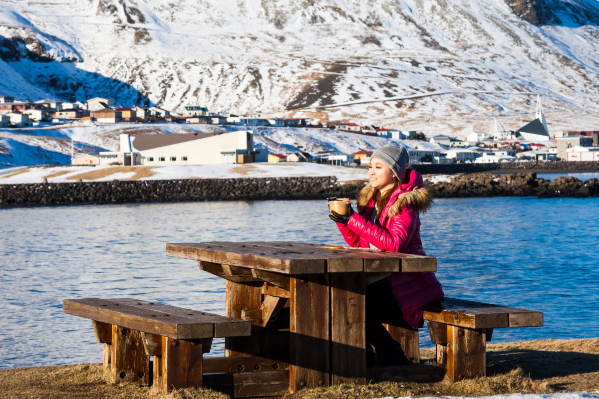 Enjoying a picnic with a view over the town Olafsvik during winter in Iceland