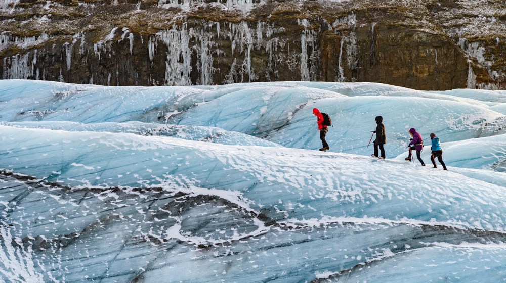 Guided hikers crossing Vatnajökull glacier with safety equipment
