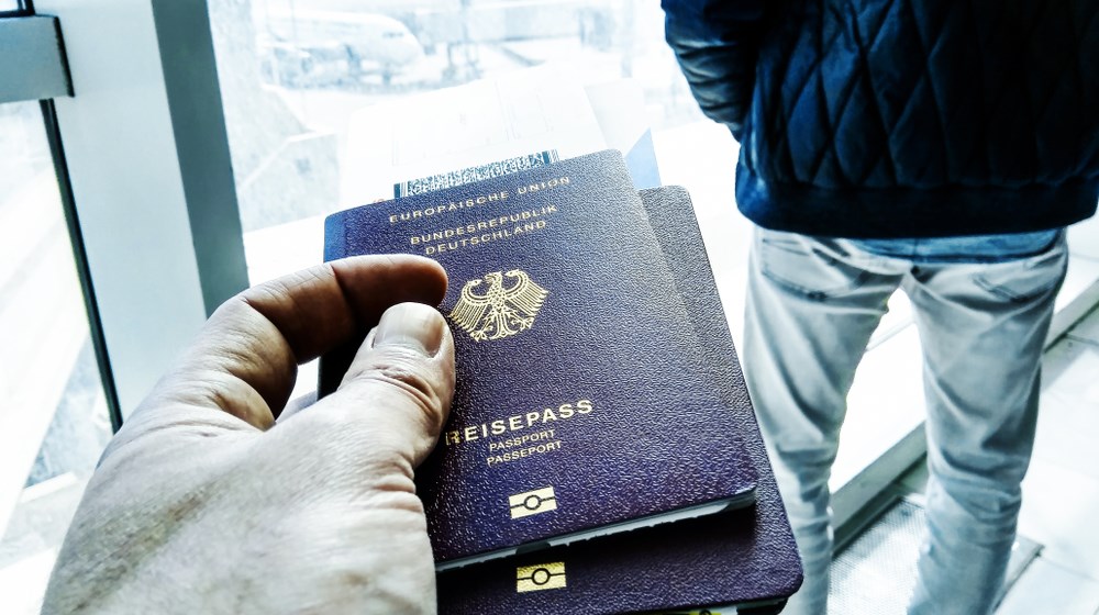Traveler holding passports and boarding documents at an airport gate
