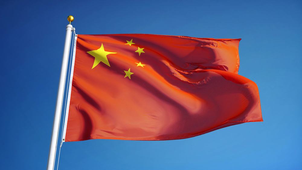 Bandera china ondeando contra un cielo azul despejado