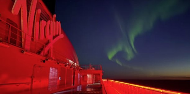 Virgin Voyages cruise ship beneath the northern lights near Iceland