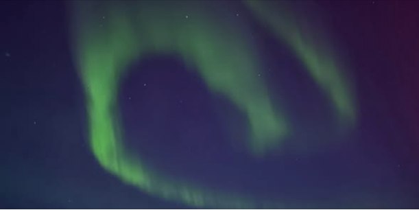 Green northern lights dancing above the North Atlantic near Iceland, photographed from a Virgin Voyages ship