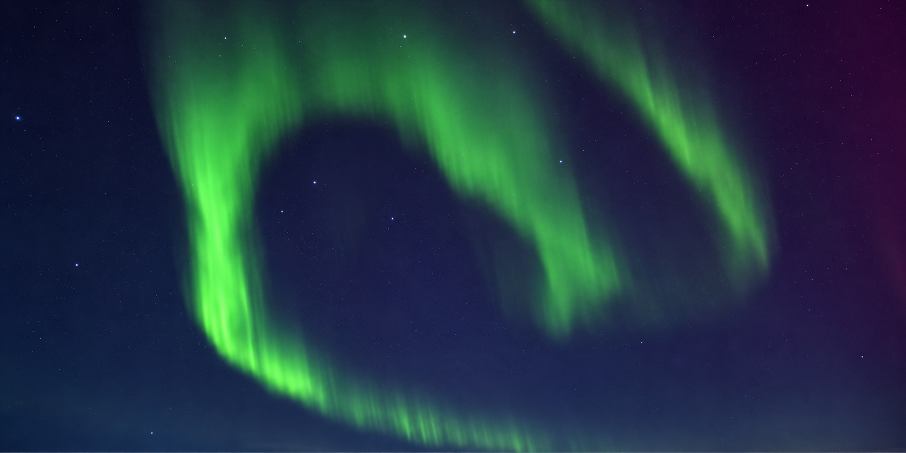 Green northern lights dancing above the North Atlantic near Iceland, photographed from a Virgin Voyages ship