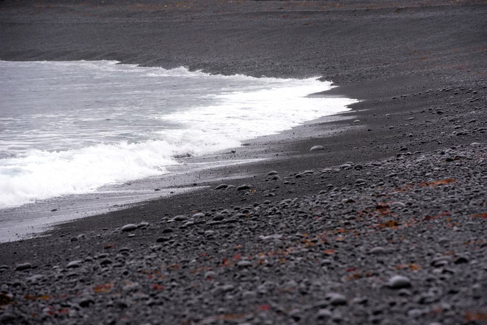 Black pebble beach and lava cliffs at Dritvík Cove